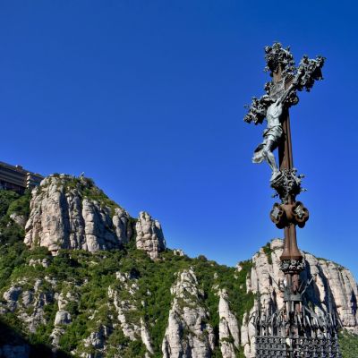 Creu de Puig i Cadafalch amb monestir al fons